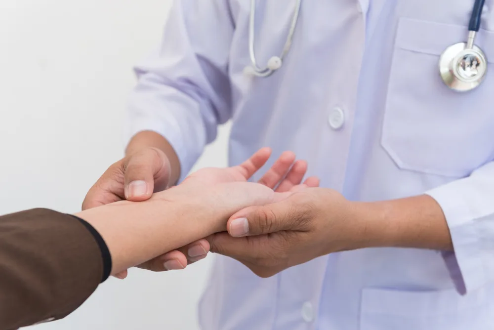 Clinician examining a patient's wrist and hand