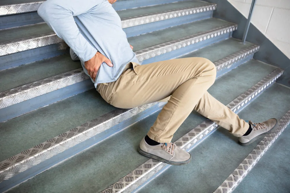 Man losing his footing on a staircase