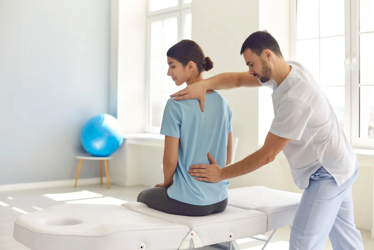 Chiropractor adjusting the back of a seated woman