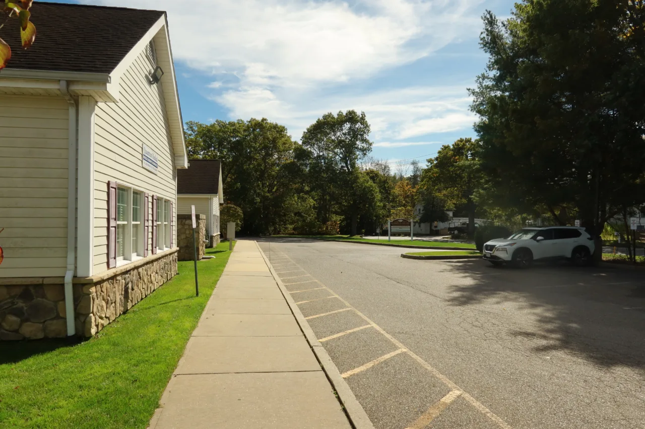Exterior of the Riverhead office, a white clapboard building with parking alongside