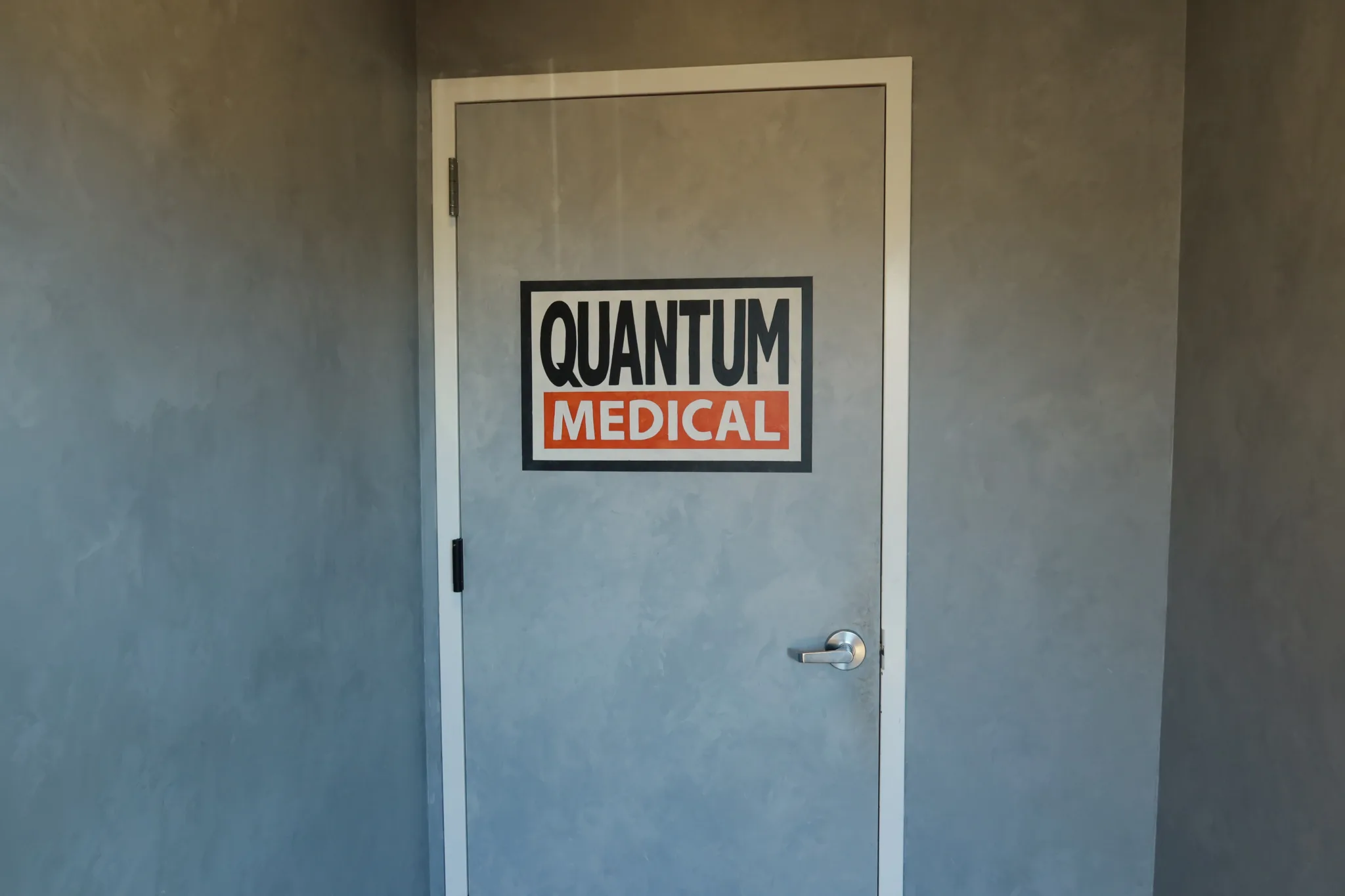 Branded sign on the wall beside the door to the treatment area