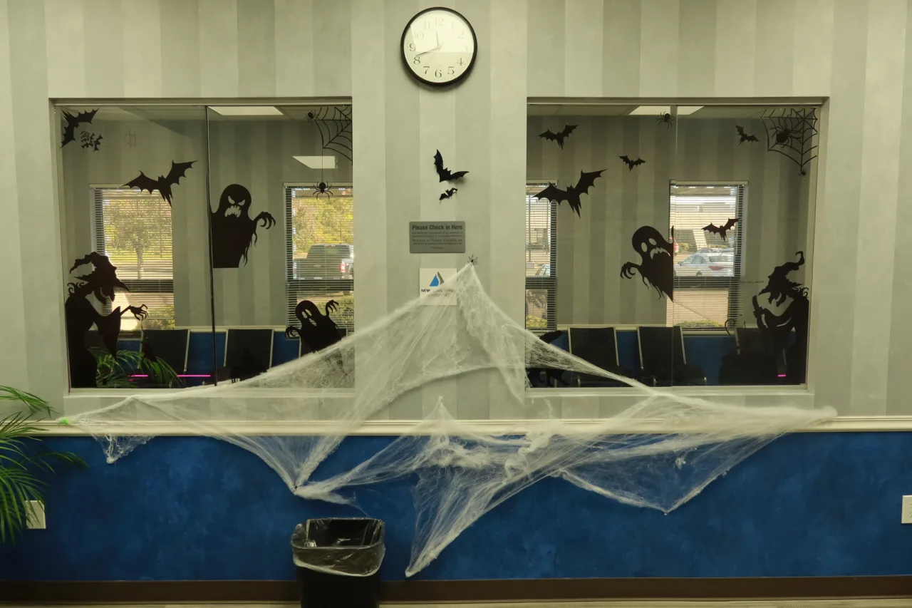 Reception window decorated for Halloween, with a clock above it