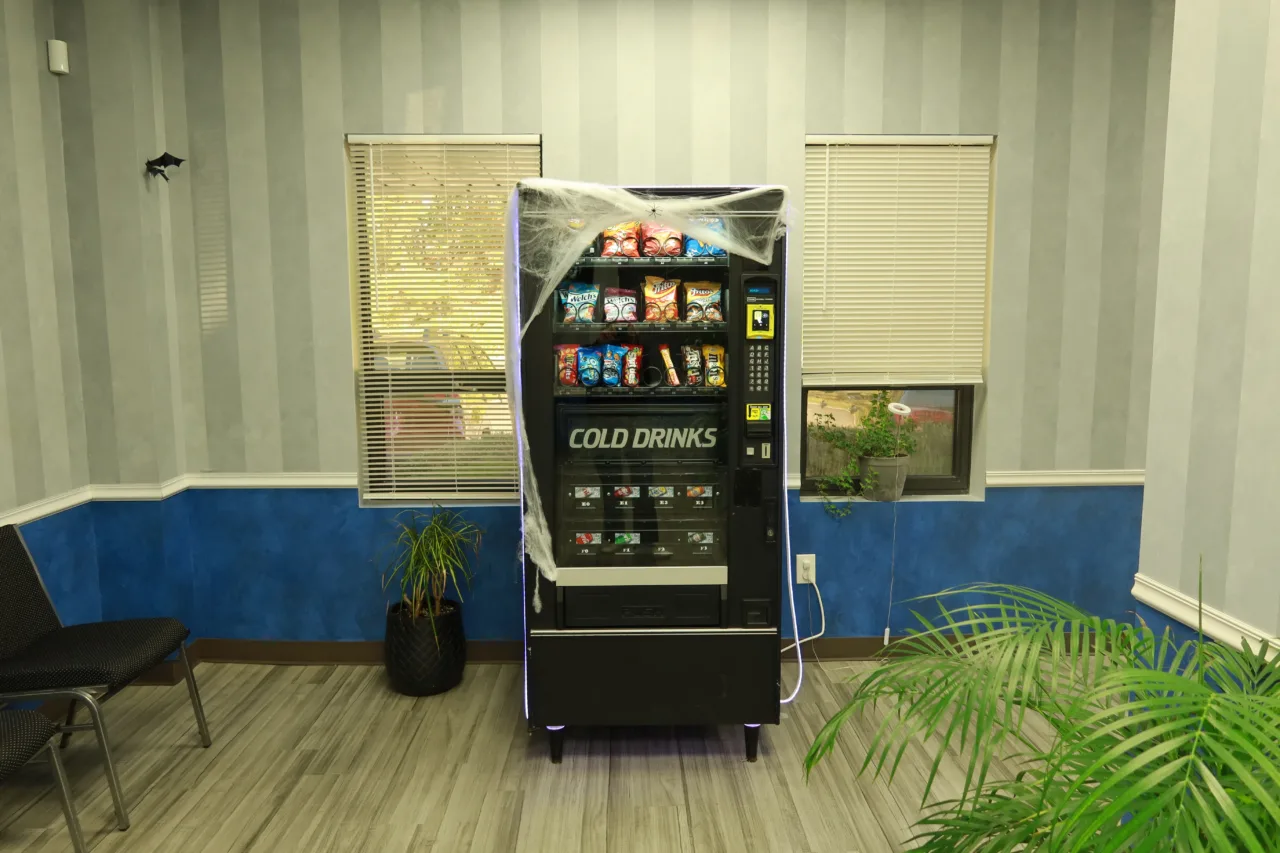 Waiting area with seating, potted plants and a snack and cold drink vending machine