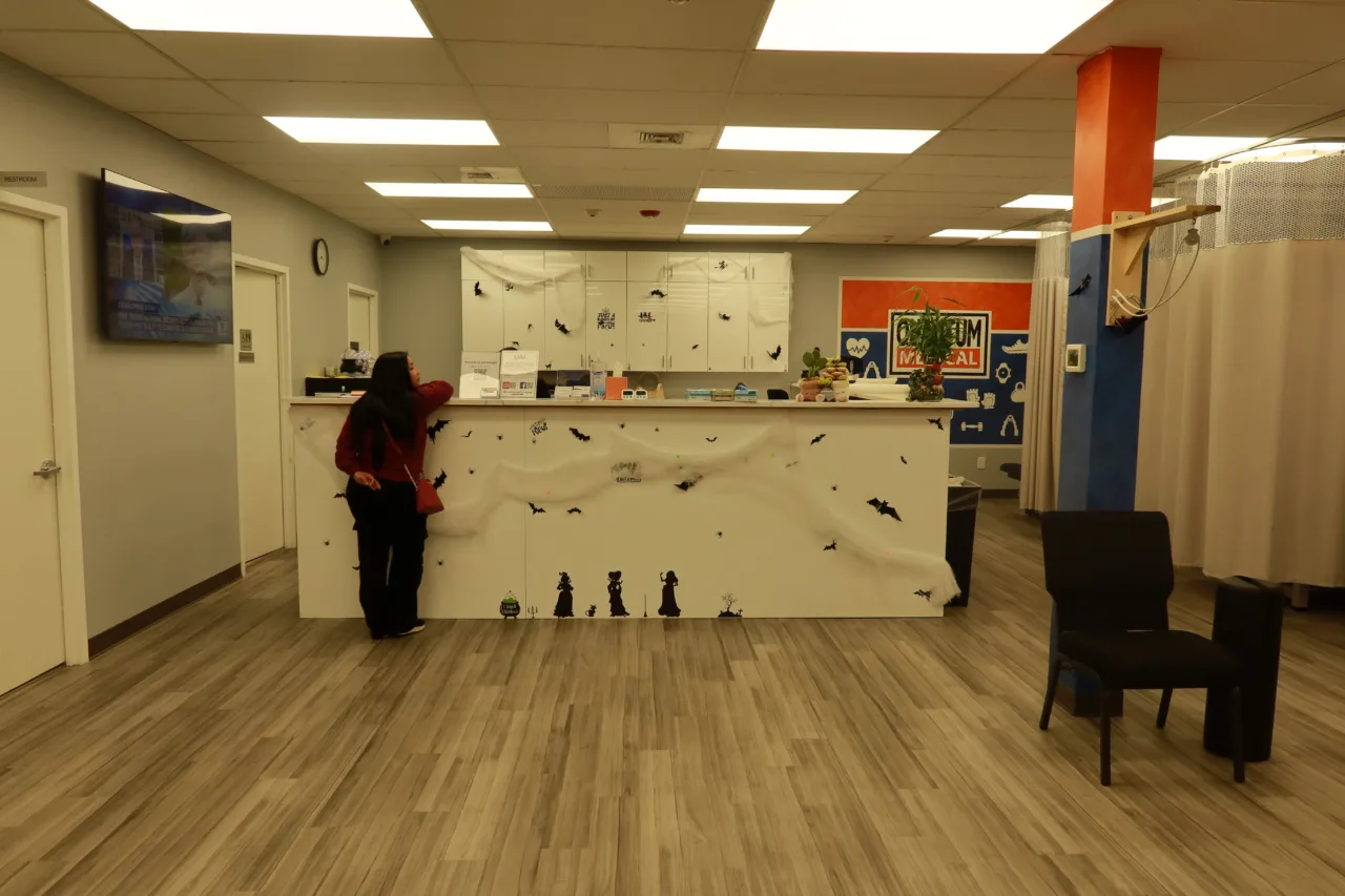Front desk decorated for Halloween, with the curtained treatment bays behind it
