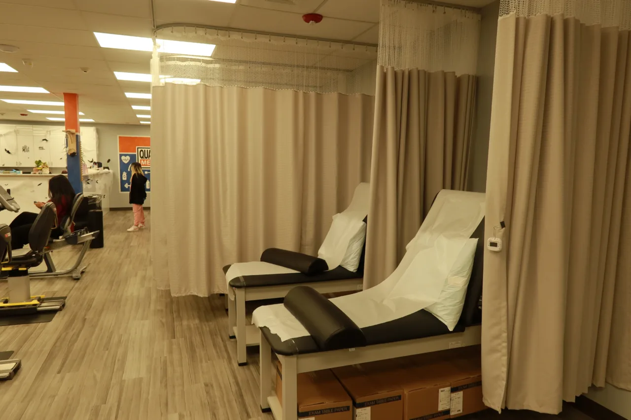 Curtained treatment bays with reclining therapy tables made up with fresh linen