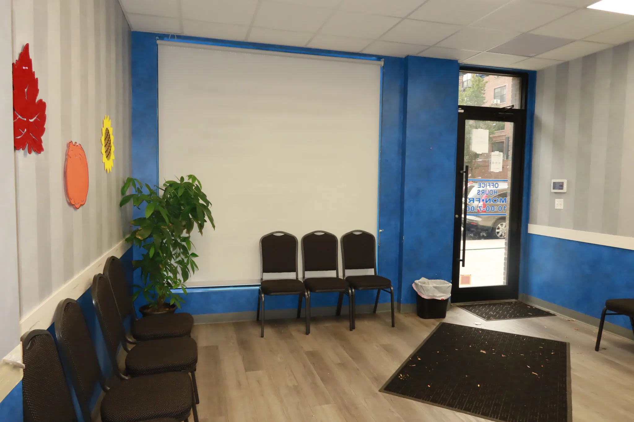 Entrance and waiting area with chairs along the wall and the street door beyond