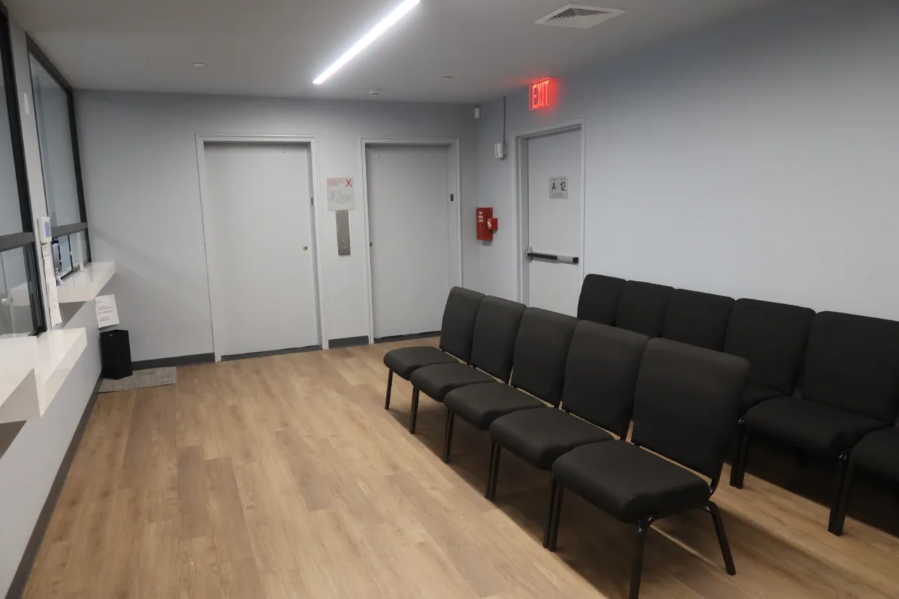 Waiting area with rows of chairs beside the doors to the treatment rooms
