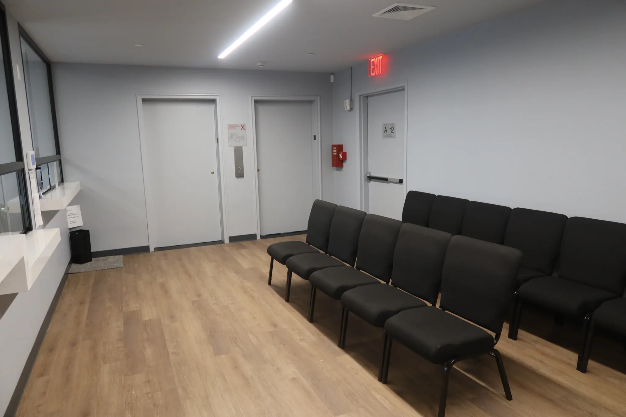 Waiting area with rows of chairs beside the doors to the treatment rooms