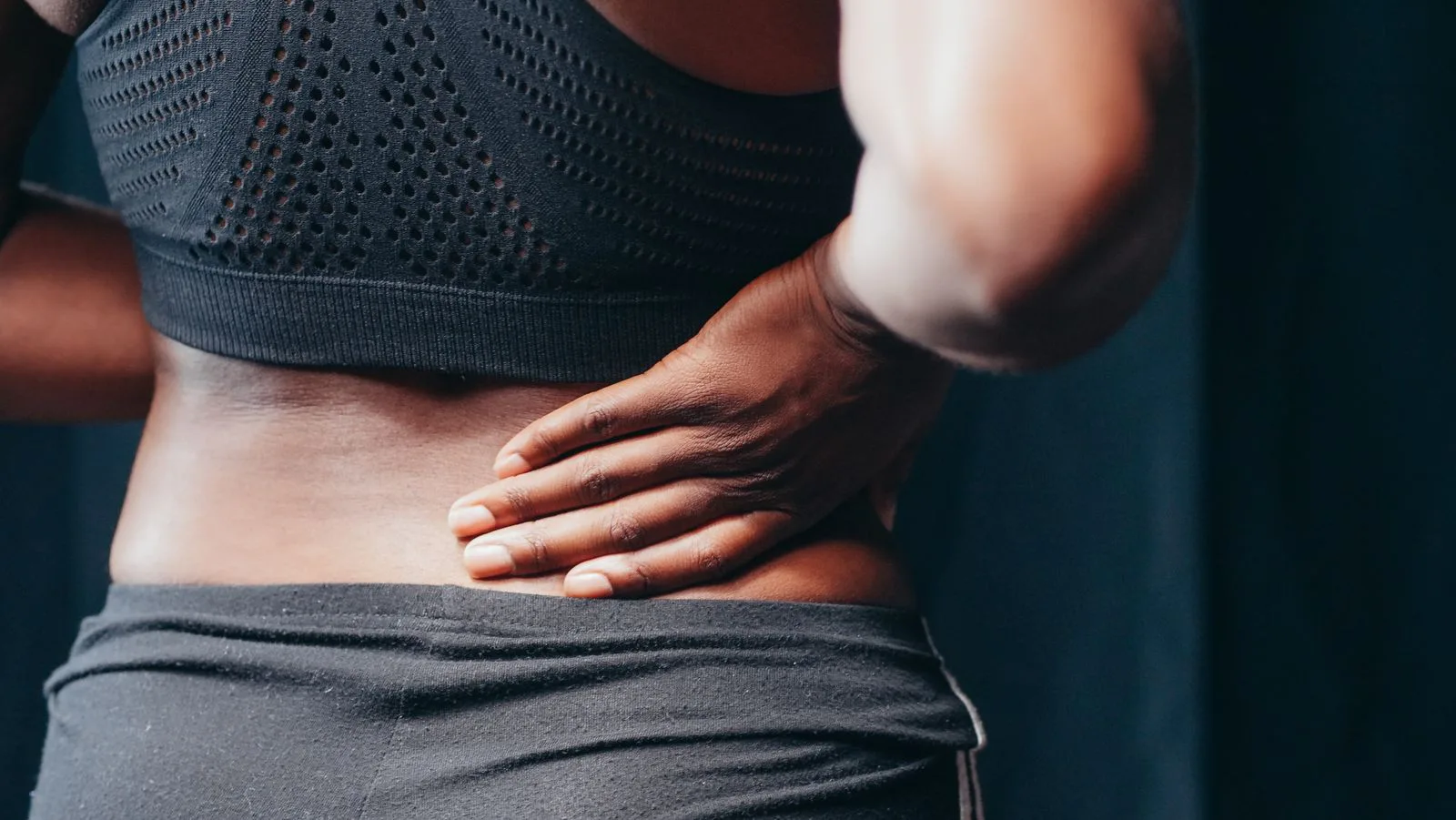 Person holding their lower back in pain