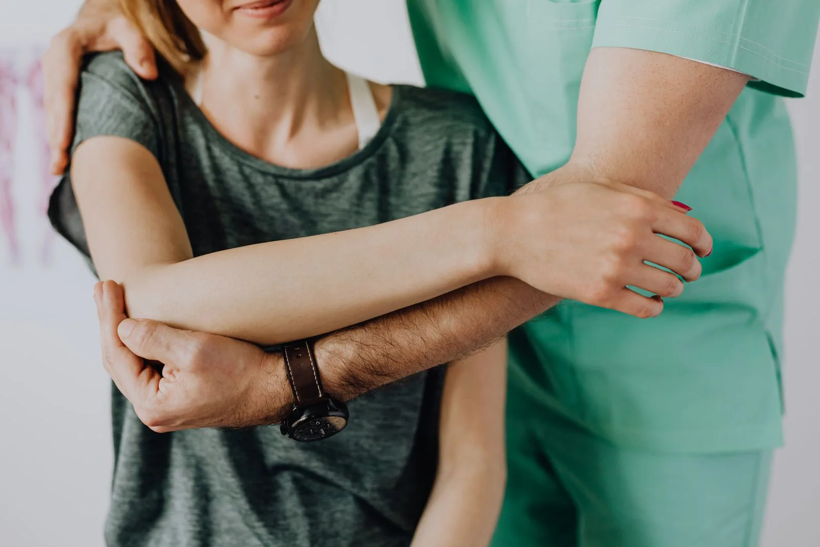 A chiropractor examines a patient's shoulder during a consultation.