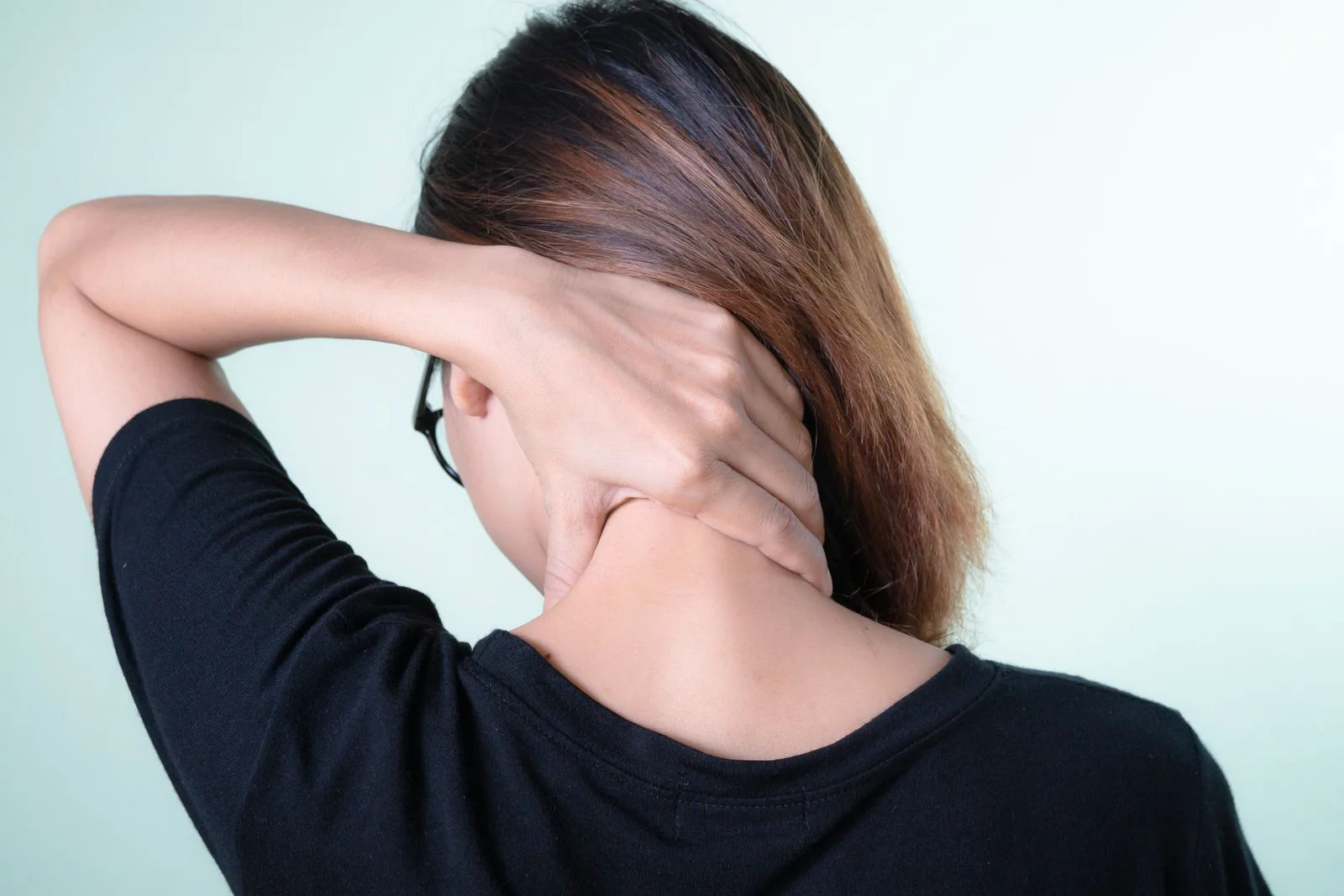 Woman rubbing the back of her sore neck