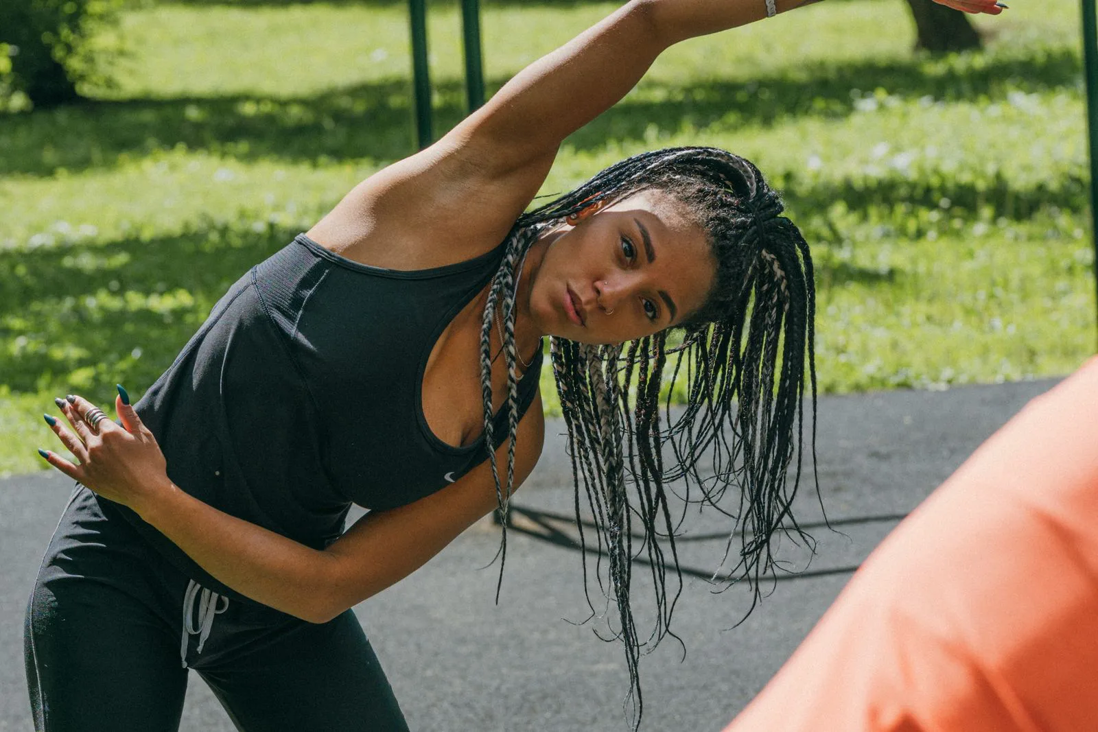 A woman stretches to one side during an outdoor warm-up.